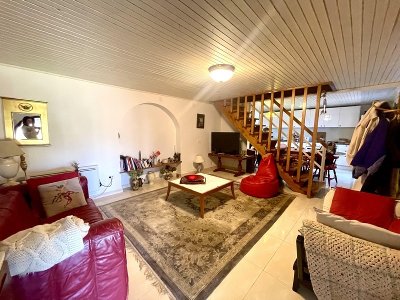 Obývací pokoj s pohovkou, kobercem a otevřeným schodištěm