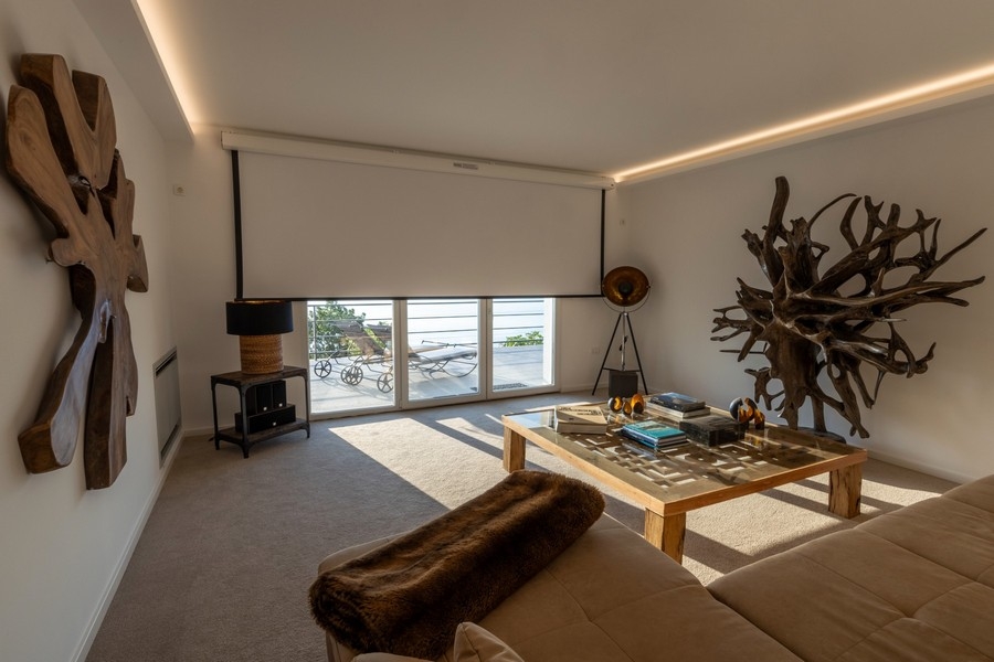 Obývací pokoj s velkými okny a výhledem na moře