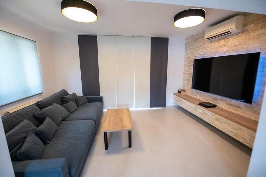 Obývací pokoj s velkou TV plochou a moderním designem stěn