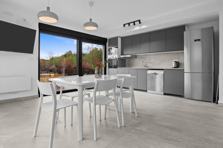 Moderní obývací a jídelní kout s otevřenou kuchyní a vstupem na terasu