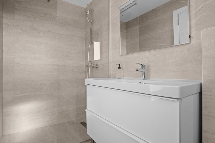 Moderní koupelna se sprchovým koutem a umyvadlem