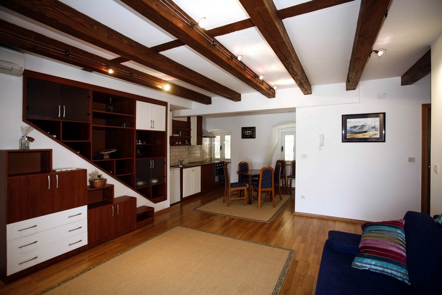 Otevřený obývací pokoj s vybavenou kuchyní a dřevěným stropem