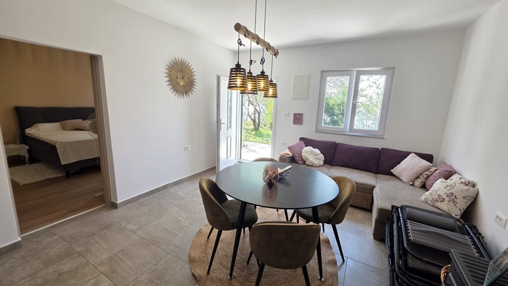 Obývací pokoj s pohovkou a jídelním stolem