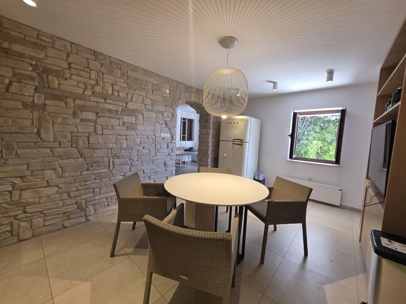 Kuchyně s kamennou zdí a moderní jídelní kout