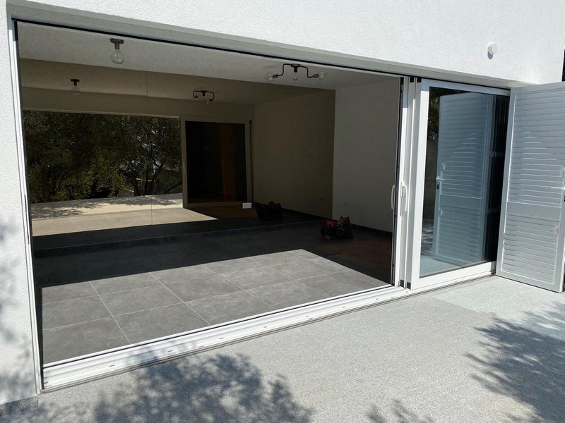 Prostorný obývací pokoj s posuvnými dveřmi na terasu