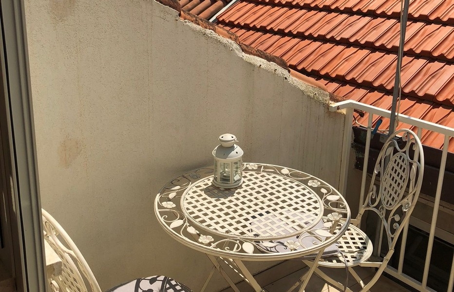 Střešní terasa s posezením a výhledem na střechy