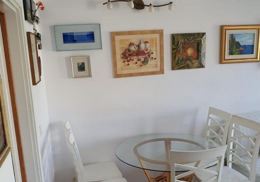 Jídelní kout s kulatým stolem a nástěnnou výzdobou