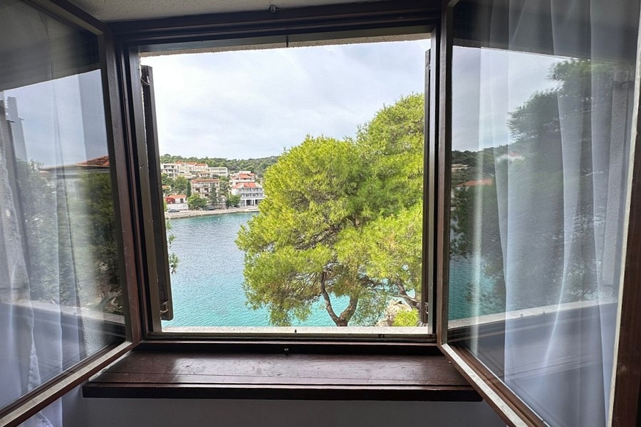 Pohled z okna na moře a protější pobřeží