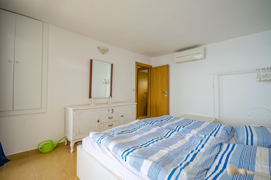 Ložnice s klimatizací a jednoduchým nábytkem