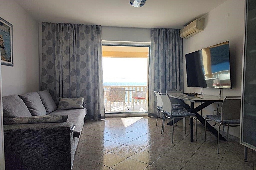 Obývací pokoj se vstupem na balkon a výhledem na moře