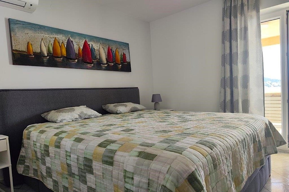 Ložnice se vstupem na balkon a výhledem na moře