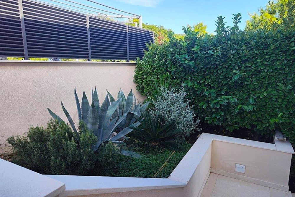 Zahrada se středomořskými rostlinami a kamennými zdmi