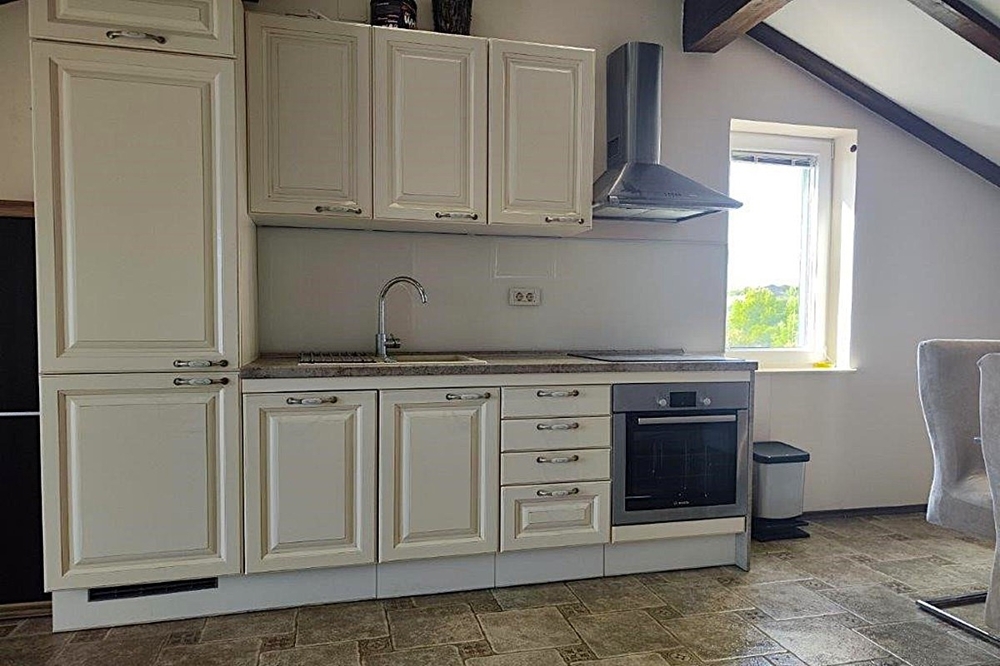 Kuchyňská linka s vestavěnými spotřebiči a zkosenými stropy