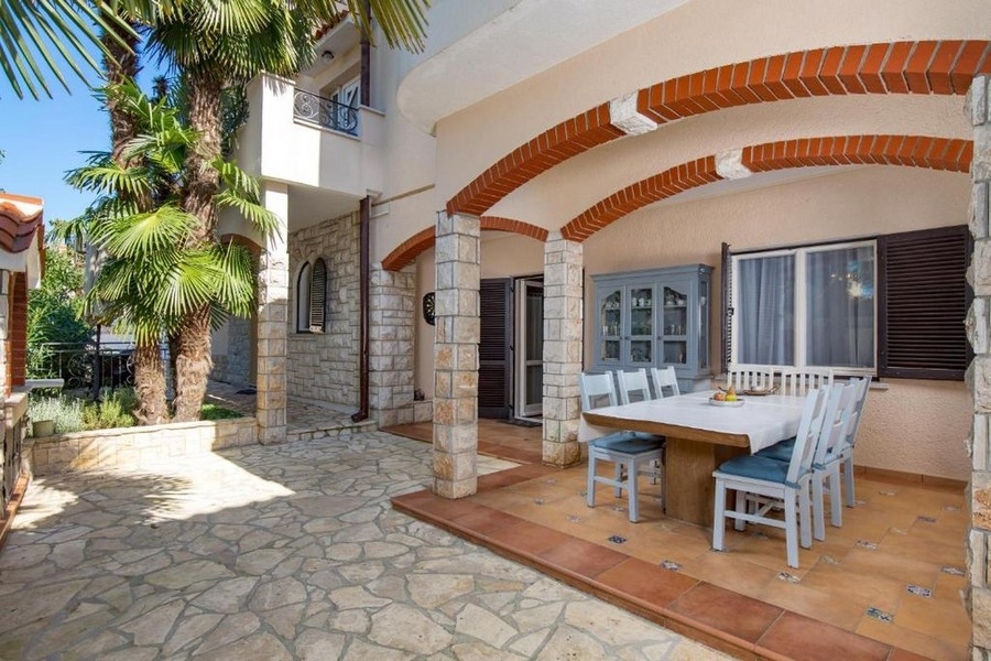 Krytá terasa s posezením a fasádou z přírodního kamene