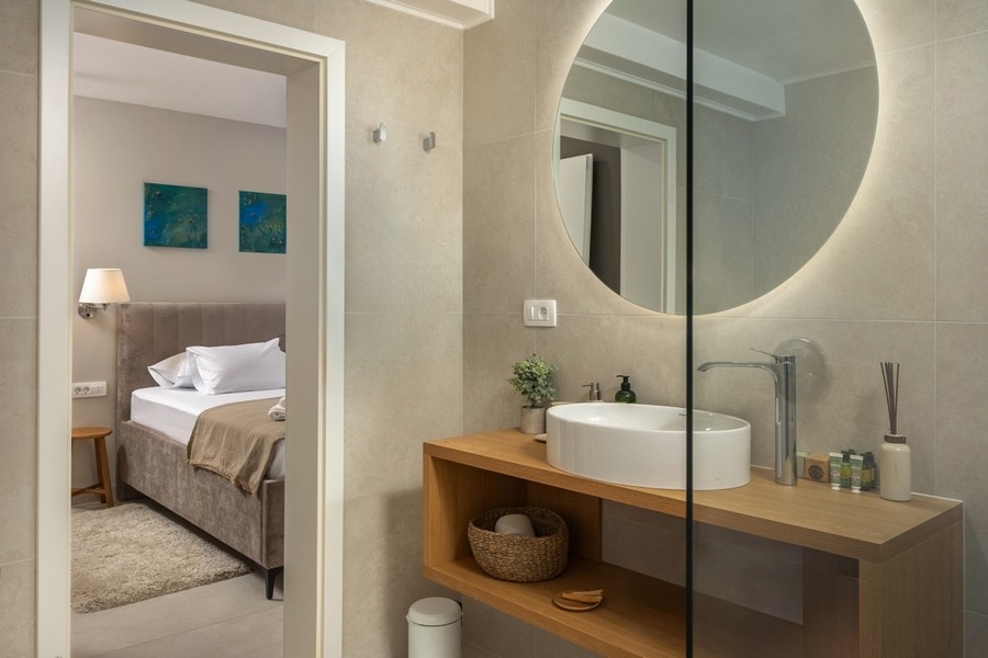 Koupelna s umyvadlem a kulatým zrcadlem