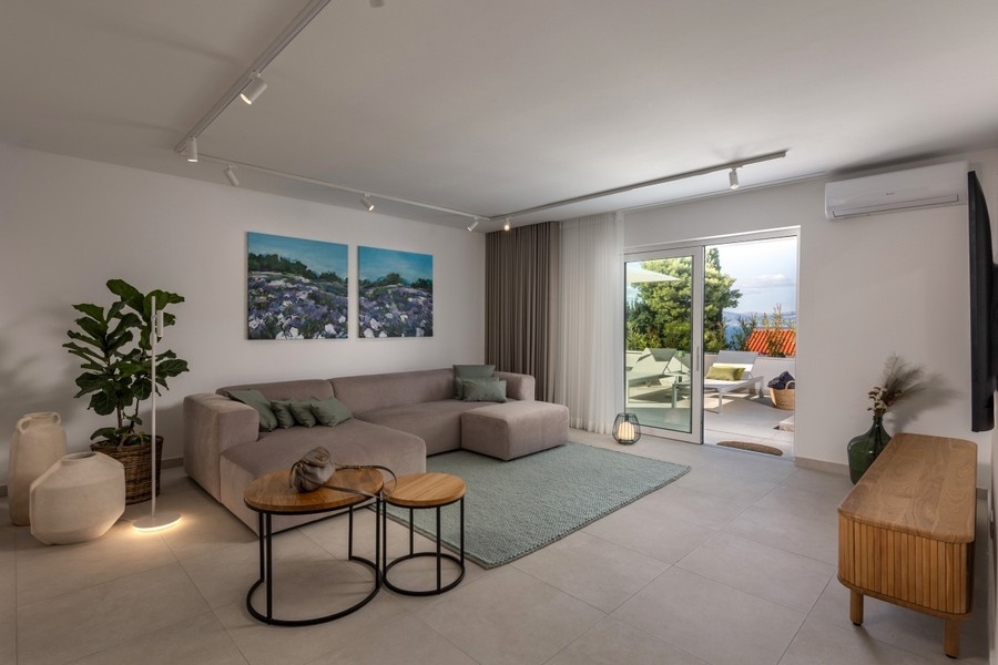 Obývací pokoj se sedací soupravou a vstupem na terasu