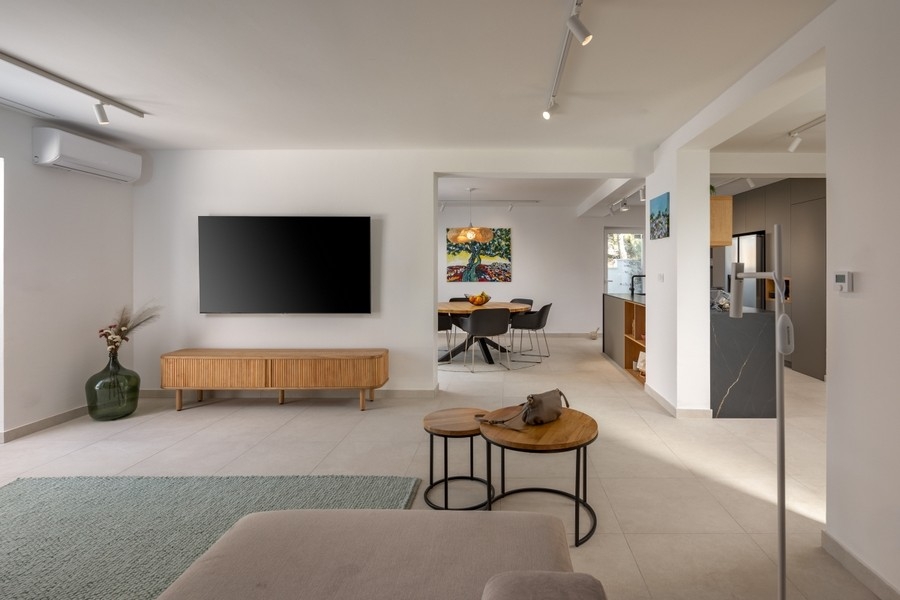 Otevřený obývací prostor s TV a průchodem do kuchyně