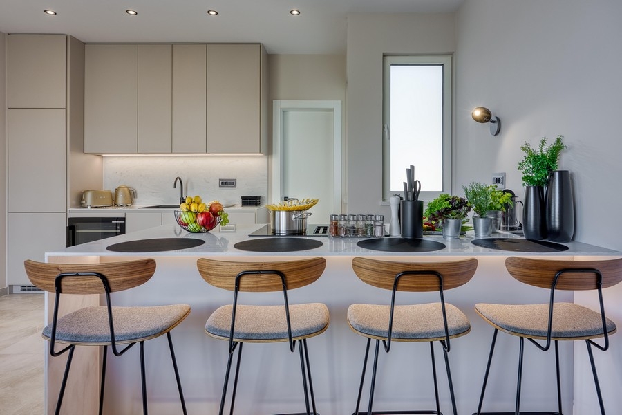 Moderní kuchyňský kout s barovými židlemi a elegantním interiérem