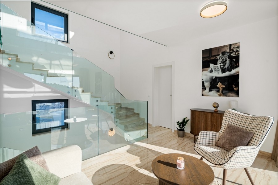 Elegantní salonek se skleněným zábradlím a moderním interiérem