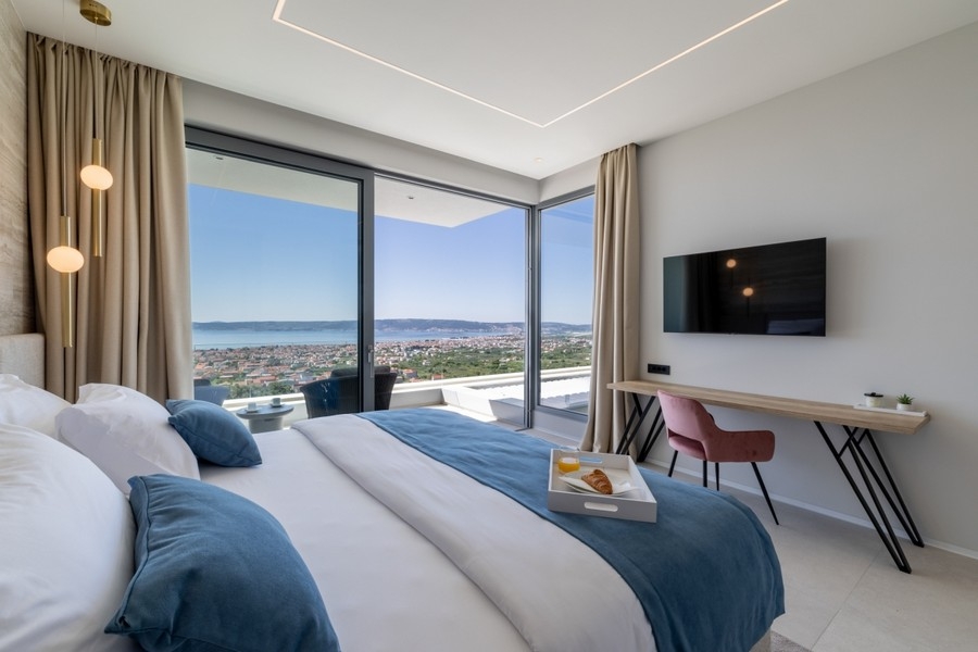 Moderní ložnice s proskleným průčelím a pobřežním panoramatem