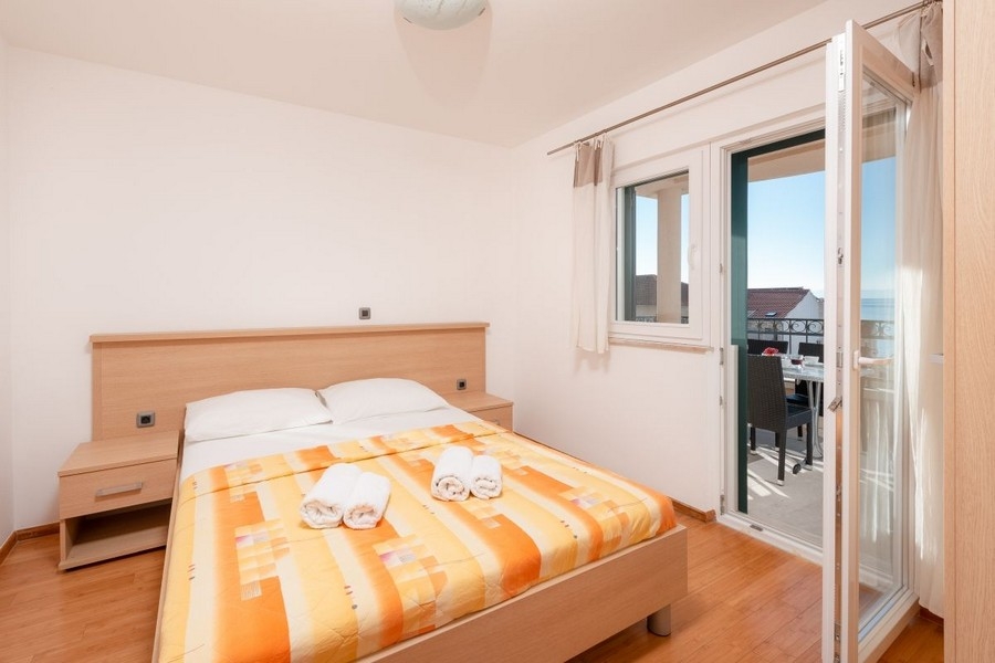 Ložnice se vstupem na balkon a výhledem na moře
