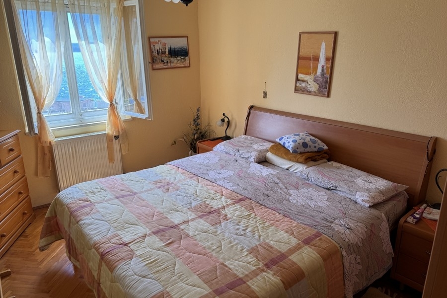 Ložnice s oknem a výhledem na moře v Chorvatsku