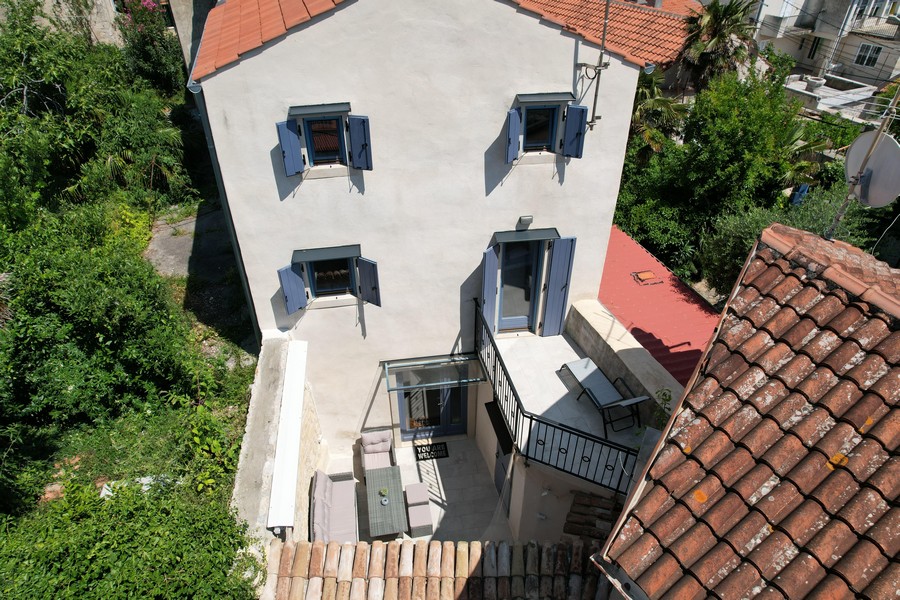 Pohled shora na terasu a balkon kamenného domu v Krku