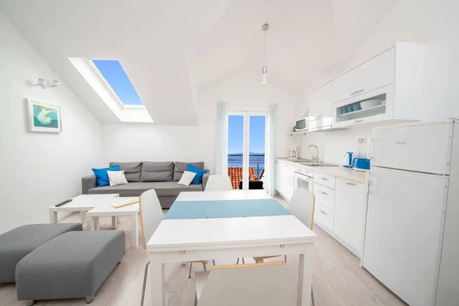 Otevřený obývací pokoj s kuchyní a výhledem na balkon