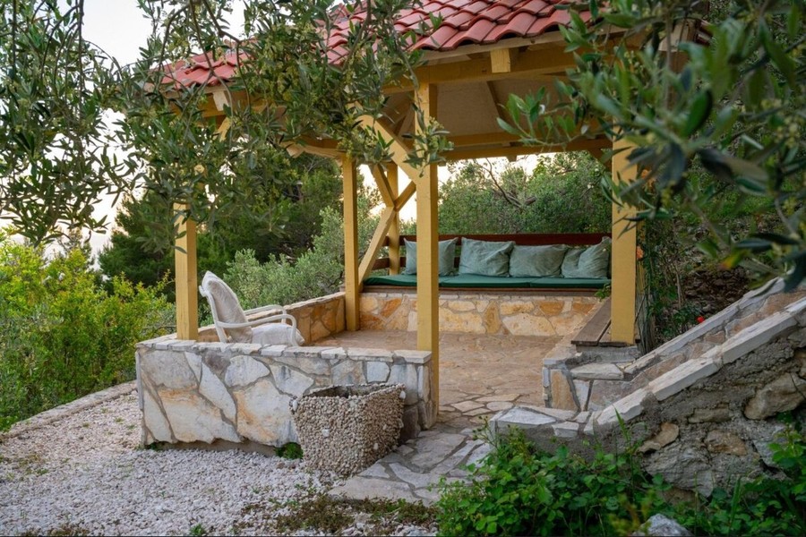 Pergola s lavičkou mezi olivovníky