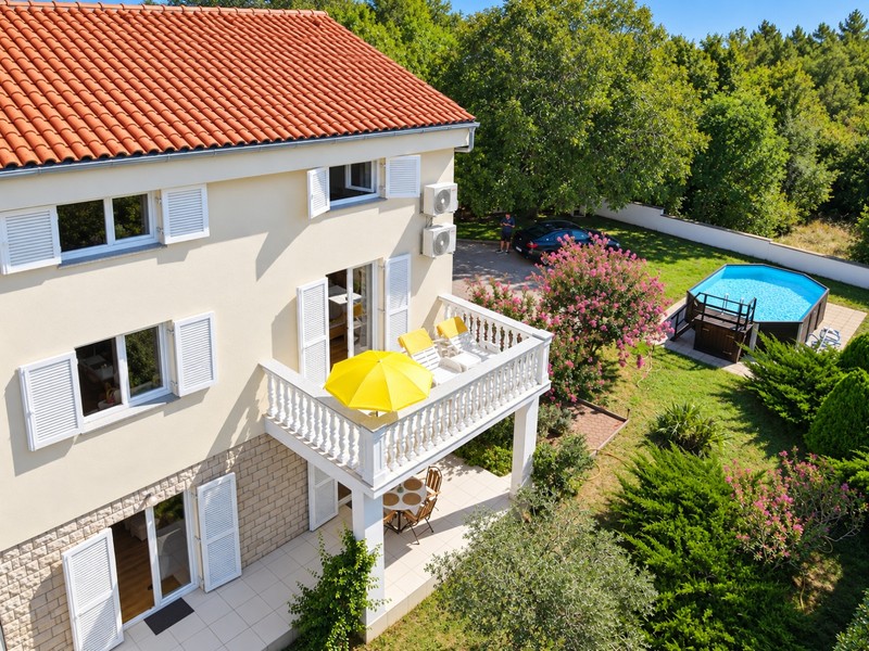Balkon s lehátky nad zahradou s bazénem