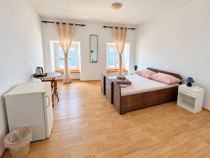 Světlá ložnice s dřevěnou podlahou