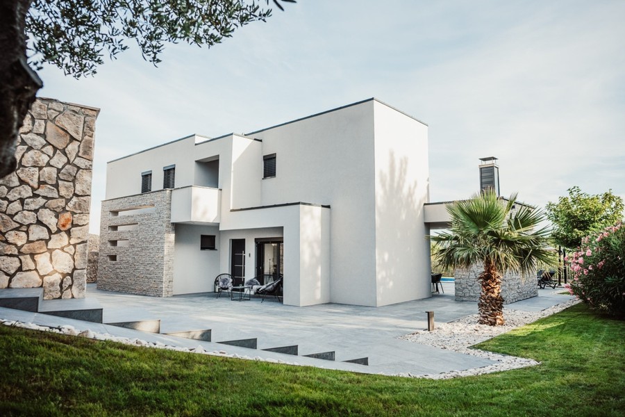 Moderní vila s trávníkem a kamennou fasádou