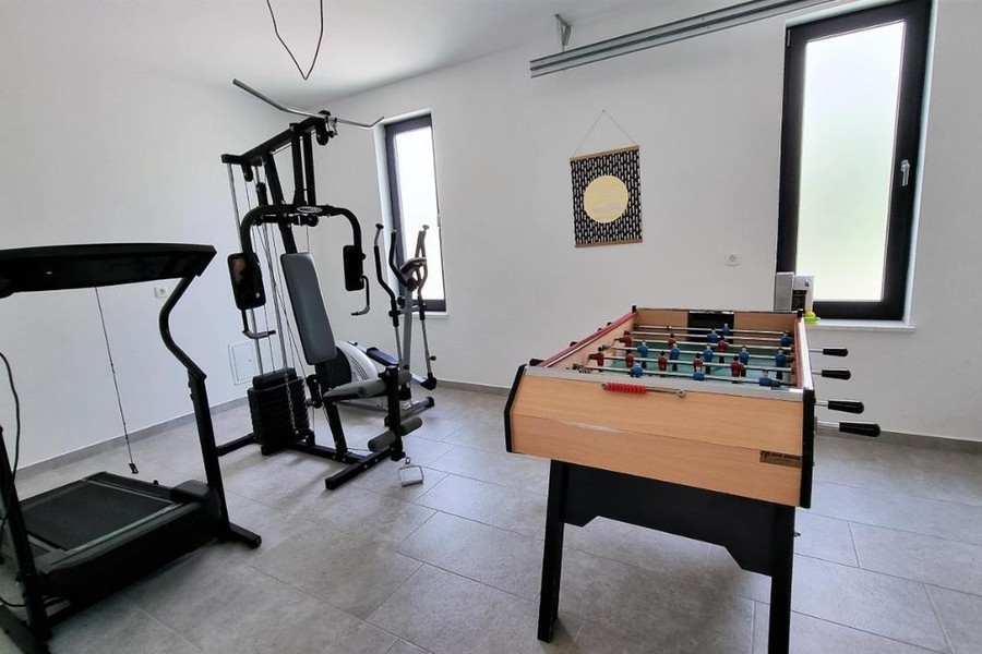 Místnost s fitness přístroji a stolním fotbálkem