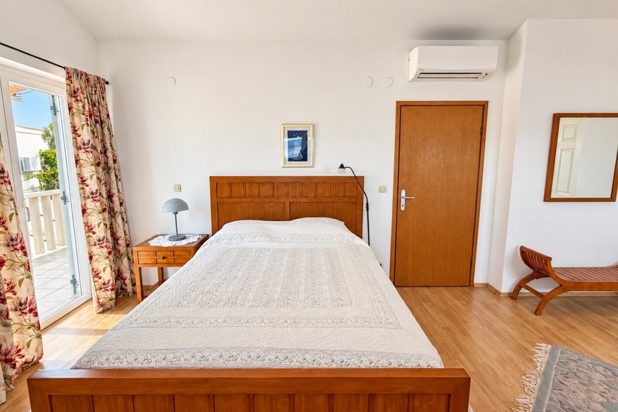 Ložnice se dřevěnou postelí a klimatizací