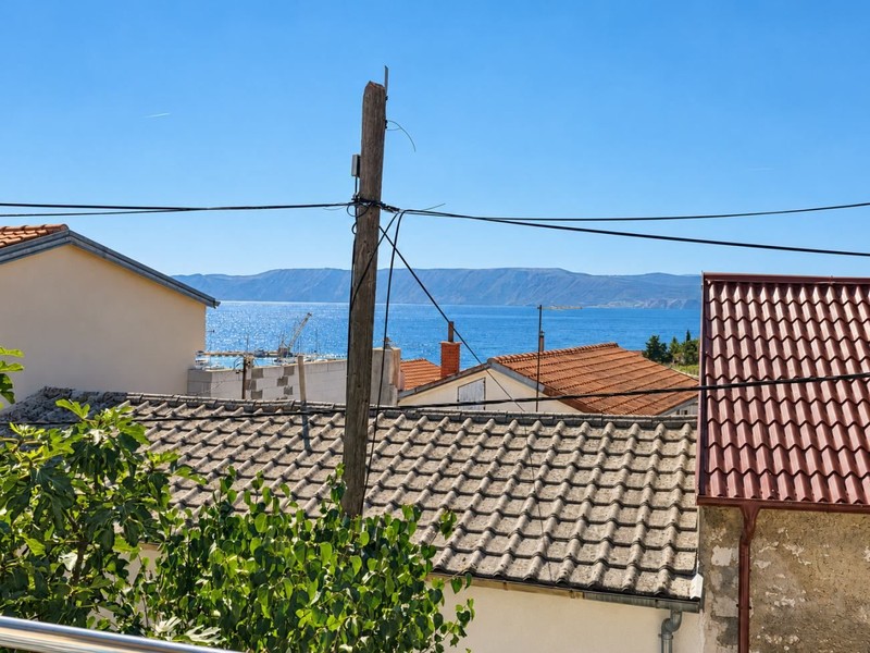 Pohled přes střechy na moře a ostrov Krk