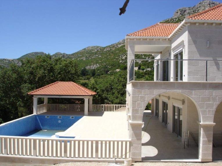 Venkovní areál s bazénem a terasami.